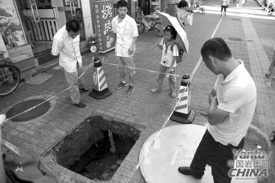 為防“坑”人，附近餐廳老板這幾天一直用一塊圓桌板把大坑蓋住